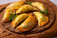 Empanadas sind gefüllte Teigtaschen, die nicht nur in Spanien, sondern als schneller Snack oder kleines Mittagessen auch in latein- und mittelamerikanischen Ländern häufig zu finden sind. Dabei werden die knusprig gebackenen Hefeteigtaschen mit unterschiedlichsten Füllungen angeboten. Neben einer Käse-Kartoffel-Füllung gibt es Empanadas oft auch mit Hackfleisch oder Tomaten. (Bild: iStock/Al Gonzalez)