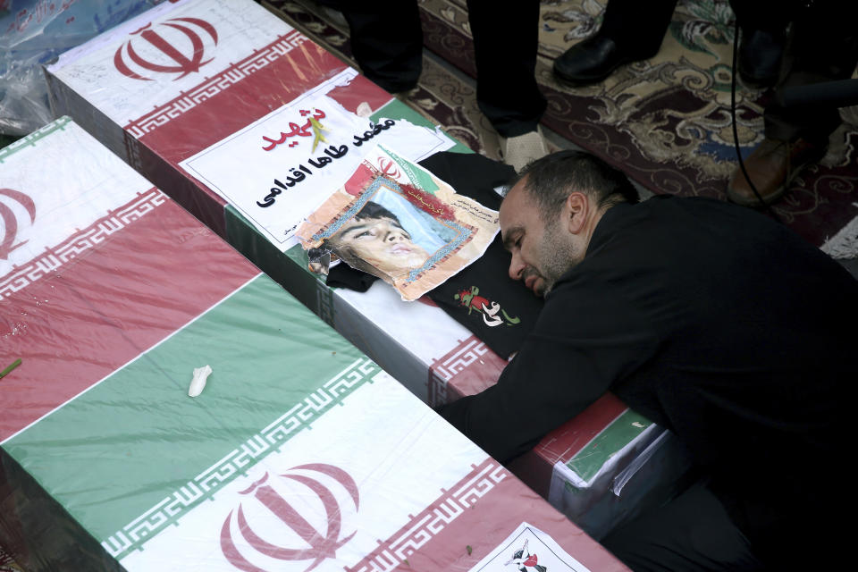 Father of Mohammad Taha Eghadami, a 4-year-old boy who was killed in Saturday's terror attack on a military parade, mourns over his coffin during a mass funeral ceremony for the victims, in southwestern city of Ahvaz, Iran, Monday, Sept. 24, 2018. Thousands of mourners gathered at the Sarallah Mosque on Ahvaz's Taleghani junction, carrying caskets in the sweltering heat. (AP Photo/Ebrahim Noroozi)