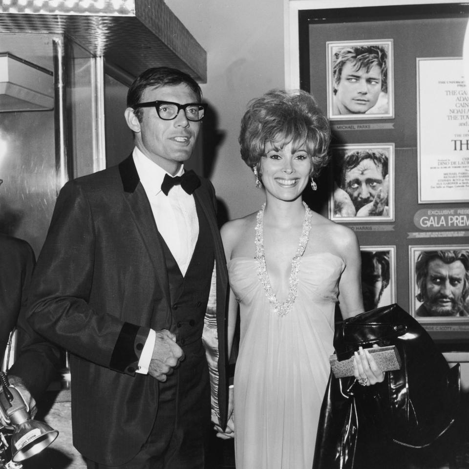 <p>Adam West and Jill St. John smile and hold hands at the premiere of director John Huston’s film, “The Bible,” Oct. 1966.’ They are standing in front of a billboard advertising the film. (Photo: Max B. Miller/Fotos International/Getty Images) </p>