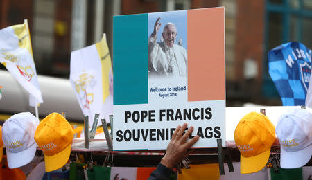 A man sells Pope Francis souvenirs from a stall in Dublin, Ireland August 24, 2018. REUTERS/Hannah McKay