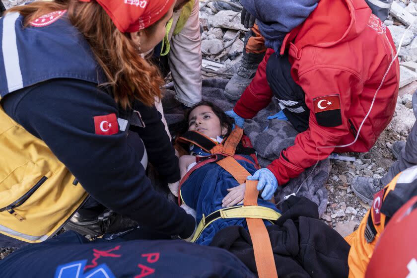 Rescue workers and medics pull out a person from a collapsed building in Antakya, Turkey, Wednesday, Feb. 15, 2023.