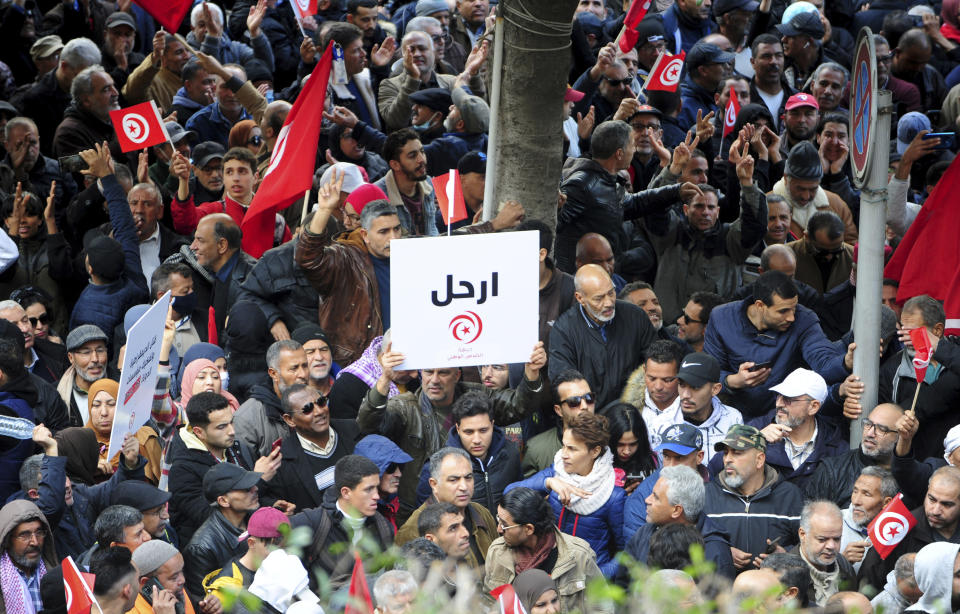 Tunisians gather during a protest against Tunisian President Kais Saied in downtown Tunis, Tunisia, Saturday Jan. 14, 2023. Tunisians mark 12 years since Tunisian protesters unleashed Arab Spring uprisings around the region. The protest comes after disastrous parliamentary elections last month in which just 11% of voters cast ballots. It also comes as the country is going through a major economic crisis, with inflation and joblessness on the rise. The banner in Arabic reads: "Leave." (AP Photo/Hassene Dridi)