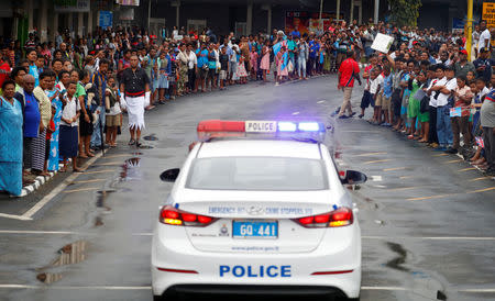 A police vehicle is seen as crowd of people stand along the street during the arrival of Britain's Prince Harry and Meghan, Duchess of Sussex, in Suva, Fiji, October 23, 2018. REUTERS/Phil Noble