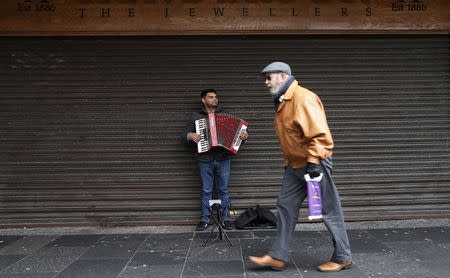 A busker plays the accordion on King Street, the main shopping street in Kilmarnock, Scotland March 27, 2014. REUTERS/Suzanne Plunkett