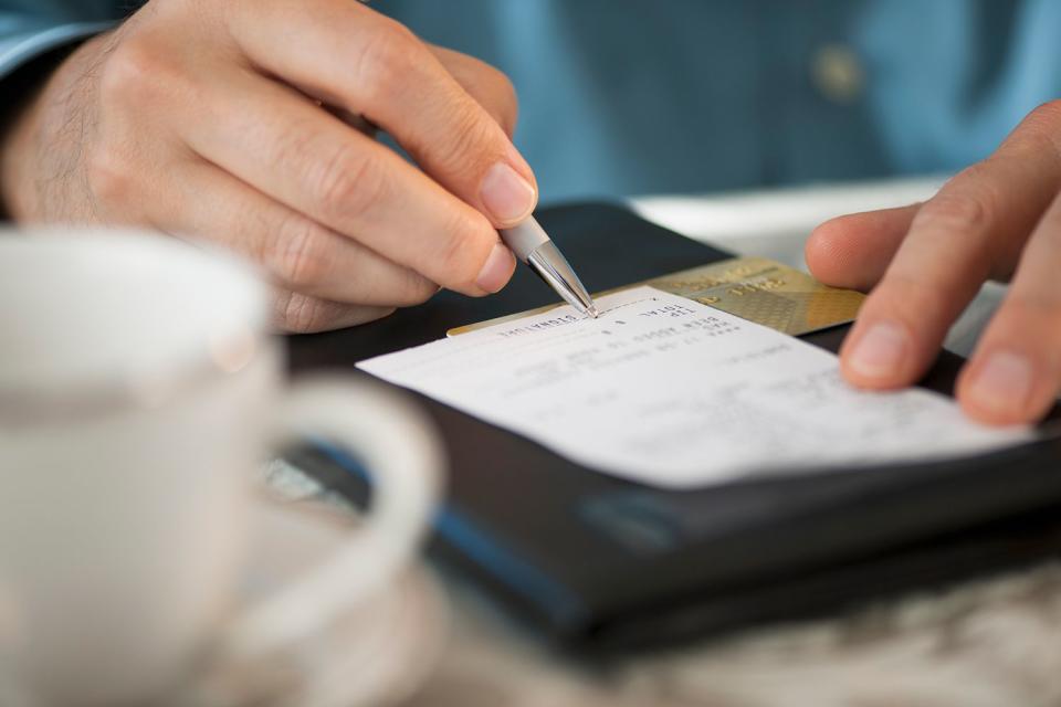 <p>Tetra Images/Getty</p> A stock photo of a customer signing a receipt