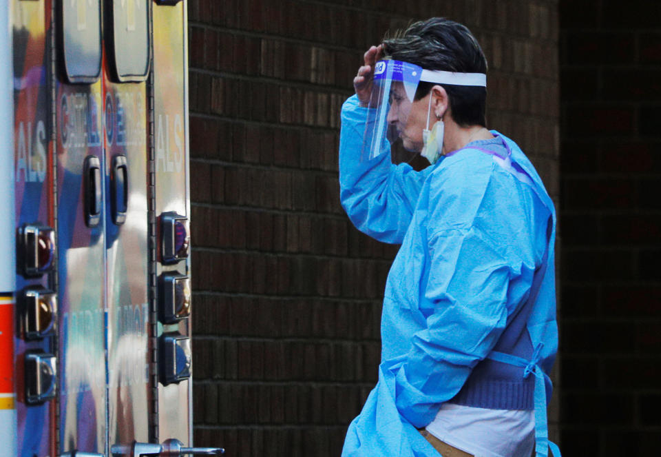  A caregiver wearing personal protective equipment (PPE) walks past an ambulance outside the Eastpointe Rehab and Skilled Care Center amid the coronavirus disease (COVID-19) outbreak in Chelsea, Massachusetts, U.S., April 17, 2020.   REUTERS/Brian Snyder