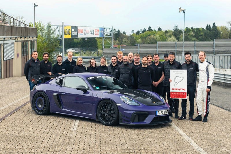 A purple Porsche 718 Cayman GT4 RS with the team who set its Nurburgring time