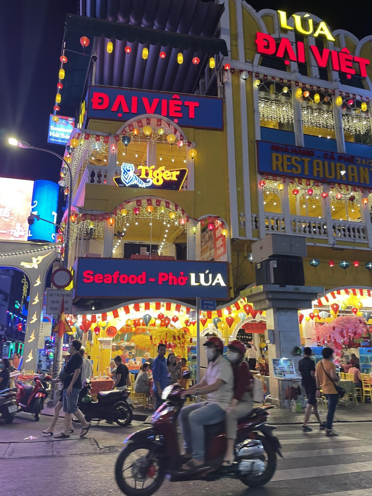 A tall building showcasing the lively night scene in the heart of Ho Chi Minh City. 