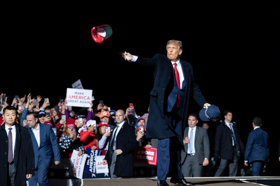 President Donald Trump tosses a hat to supporters as he arrives to speak at a campaign rally at Duluth International Airport on Sept. 30 in Minnesota.