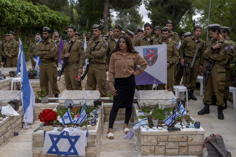 Israeli soldiers and family members of fallen soldiers visit their graves on the eve of the country's annual Memorial Day for fallen soldiers and victims of nationalistic attacks, at Mount Herzl military cemetery, in Jerusalem, Sunday, May 12, 2024. (AP Photo/Ohad Zwigenberg)