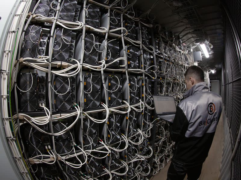 A technician inspects mining rigs at BitCluster's mine in Norilsk, Siberia. (BitCluster)