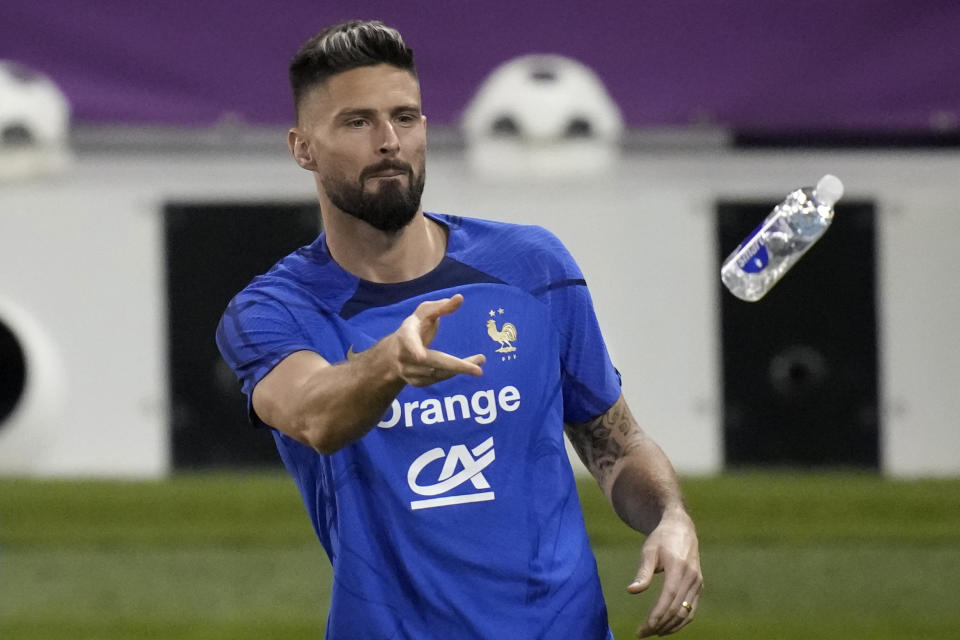 France's Olivier Giroud throws a bottle of water during a training session at the Jassim Bin Hamad stadium in Doha, Qatar, Sunday, Nov. 20, 2022. France will play their first match in the World Cup against Australia on Nov. 22. (AP Photo/Christophe Ena)