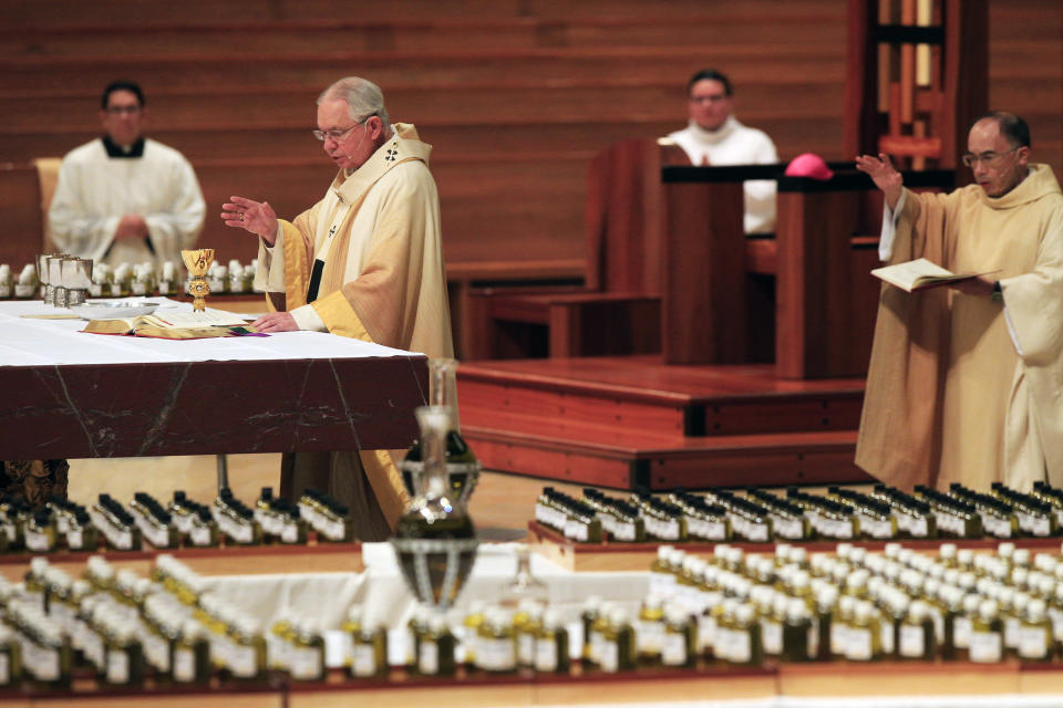 FILE - In this April 6, 2020 file photo, Los Angeles Archbishop Jose H. Gomez, front, celebrates the Chrism Mass for the faithful of the nation's largest Catholic Archdiocese in Los Angeles. California says churches can resume in-person services but the congregations will be limited to less than 100 and worshippers should wear masks, avoid sharing prayer books and skip the collection plate. The state Department of Public Health released a framework Monday, May 25, for county health officials to permit houses of worship to reopen. (AP Photo/Damian Dovarganes, File)