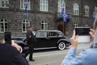 People take photos as Iceland's president Guðni Th. Jóhannesson is driven away in a car following his inauguration in Reykjavik, Iceland Saturday Aug. 1, 2020. In Iceland, a nation so safe that its president runs errands on a bicycle, U.S. Ambassador Jeffery Ross Gunter has left locals aghast with his request to hire armed bodyguards. He's also enraged lawmakers by casually and groundlessly hitching Iceland to President Donald Trump's controversial "China virus” label for the coronavirus. (AP Photo/Árni Torfason)