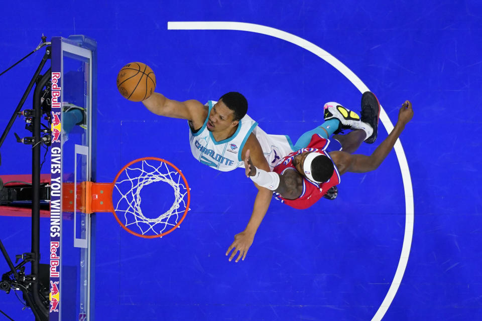 Charlotte Hornets' Grant Williams, left, goes up for a shot against Philadelphia 76ers' Paul Reed during the first half of an NBA basketball game, Friday, March 1, 2024, in Philadelphia. (AP Photo/Matt Slocum)