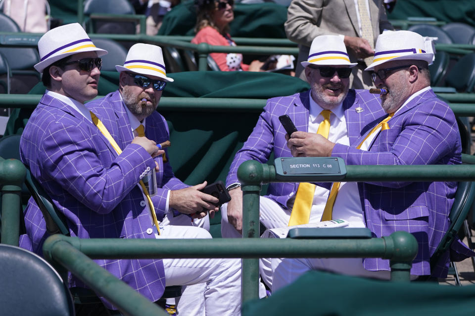 Men talk as they watch a race before the 147th running of the Kentucky Derby at Churchill Downs, Saturday, May 1, 2021, in Louisville, Ky. (AP Photo/Michael Conroy)