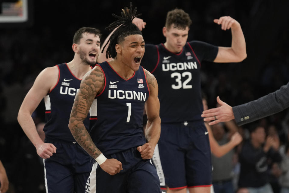 UConn's Alex Karaban, left, Solomon Ball (1), center, and Donovan Clingan (32) react during the second half of an NCAA college basketball game against Indiana, Sunday, Nov. 19, 2023, in New York. (AP Photo/Seth Wenig)