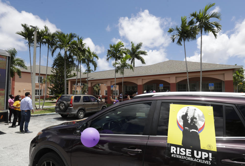 A caravan of union members stop outside the Franco Nursing & Rehabilitation Center to hand out masks to prevent the spread of the new coronavirus and lunches to workers, Monday, July 20, 2020, in Miami. Most facilities, experts and industry leaders told The Associated Press that a statewide mask mandate would help protect staff members, and consequently residents, from the virus. (AP Photo/Wilfredo Lee)