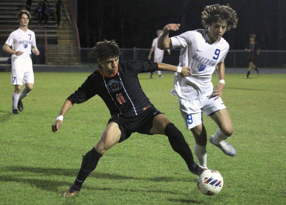 Mandarin forward Antonio Mancinotti (11) and Bartram Trail midfielder Aaron Kadas (9) challenge for possession  during the FHSAA District 1-7A high school boys soccer final on February 2, 2023. [Clayton Freeman/Florida Times-Union]