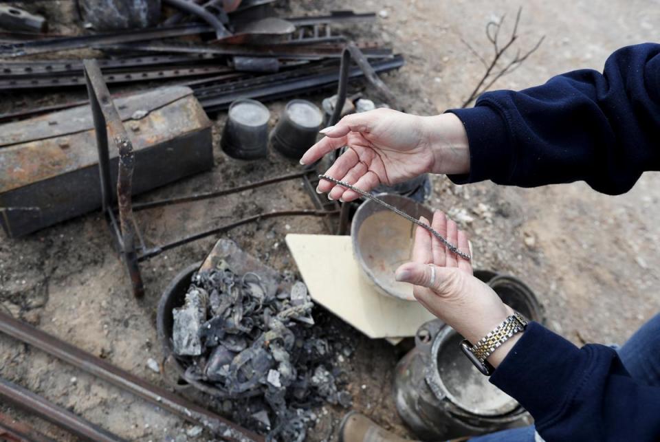 Brooke McQuiddy holds a gold chain recovered from her mother, Melanie McQuiddy’s property. Canadian, Tx. residents were cleaning up and recovering from the massive wild fires that burned much of the northern Texas panhandle.