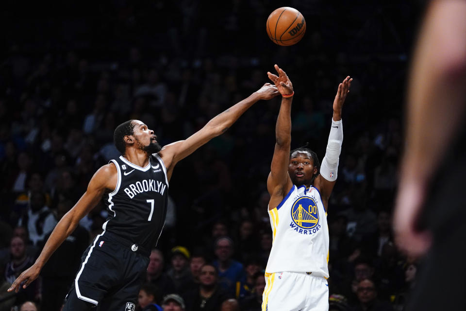 Brooklyn Nets' Kevin Durant (7) defends a shot by Golden State Warriors' Jonathan Kuminga (00) during the first half of an NBA basketball game Wednesday, Dec. 21, 2022 in New York. (AP Photo/Frank Franklin II)