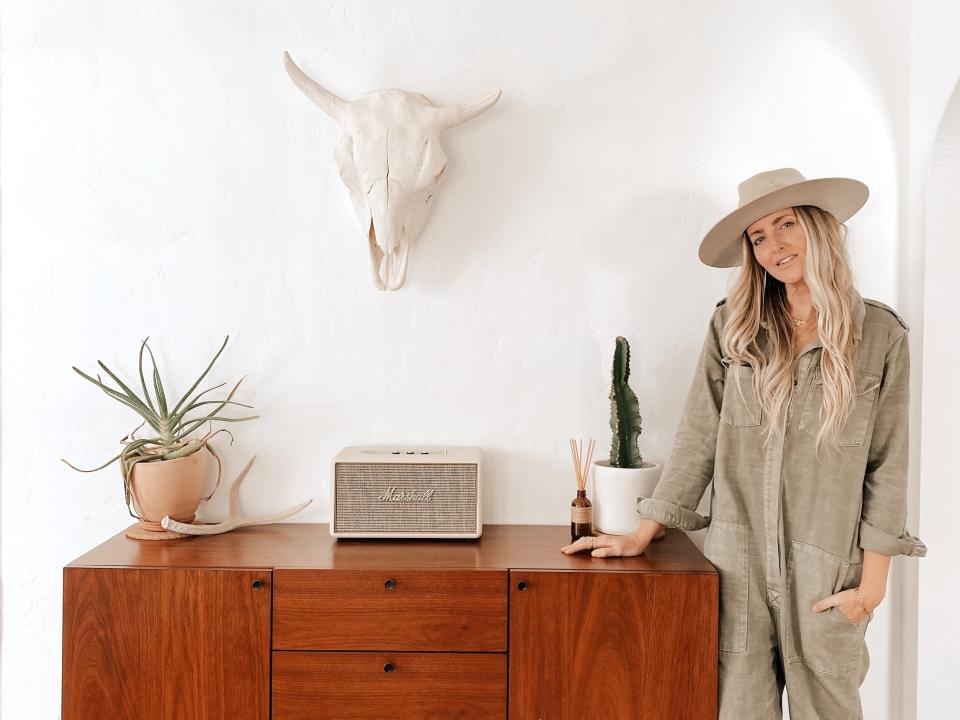 Laura Genevieve standing beside a shelf.