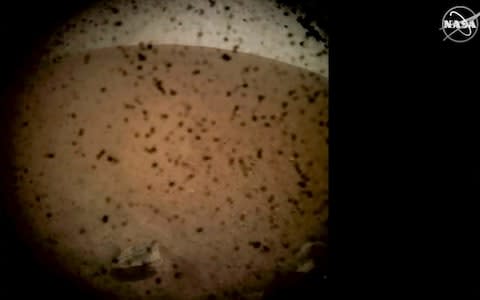 Debris is seen on the lens in the first image from NASA's InSight lander after it touched down on the surface of Mars - Credit: GETTY