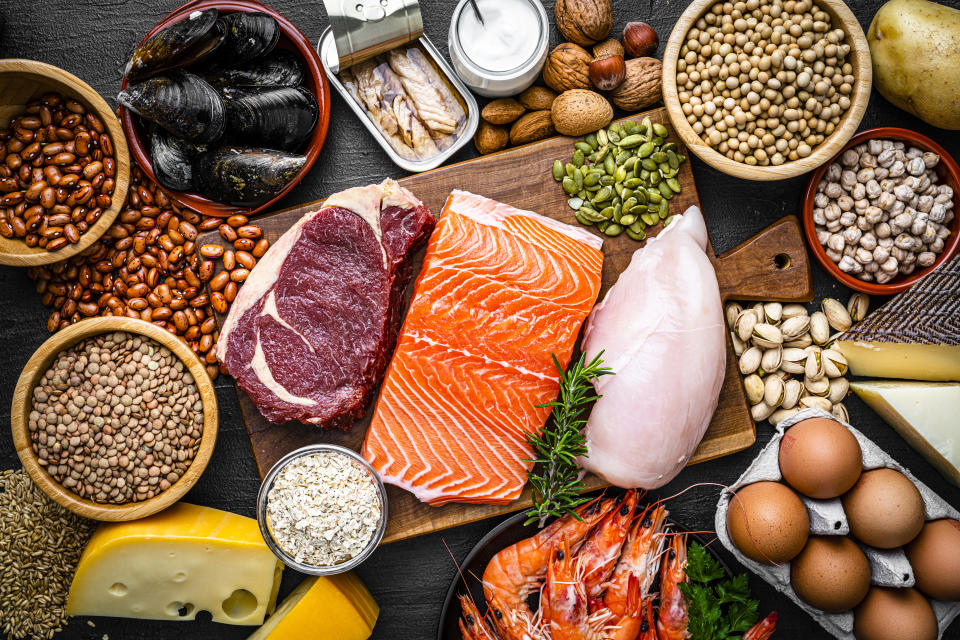 Overhead view of a large group of food with high content of healthy proteins. The composition includes salmon beef fillet, chicken breast, eggs, yogurt, mussels, chick peas, pistachios, cheese, brown lentild, beans, shrimps, canned tuna, pumpkin seeds, soybeans among others. High resolution 42Mp studio digital capture taken with SONY A7rII and Zeiss Batis 40mm F2.0 CF lens