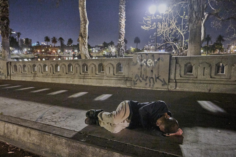 A man suffering homelessness sleeps on the bare sidewalk early morning Wednesday, June 26, 2024 at McCarthur Park in Los Angeles. The number of homeless residents counted in Los Angeles County has dipped slightly, decreasing by about 0.3% since last year as California continues to struggle with the long-running crisis of tens of thousands of people sleeping in cars and encampments. (AP Photo/Damian Dovarganes)