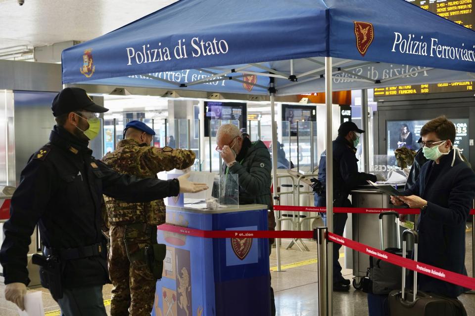 Border police check travelers documents at a check point inside Rome's Termini train station, Tuesday, March 10, 2020. In Italy the government extended a coronavirus containment order previously limited to the country’s north to the rest of the country beginning Tuesday, with soldiers and police enforcing bans. (AP Photo/Andrew Medichini)