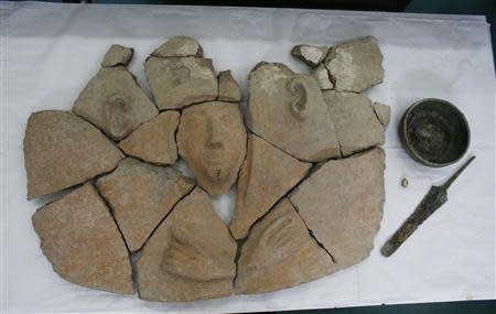 Parts of a broken coffin and other artefacts displayed for the media are seen at Israel Antiquities Authority offices in Jerusalem April 9, 2014. REUTERS/Ronen Zvulun