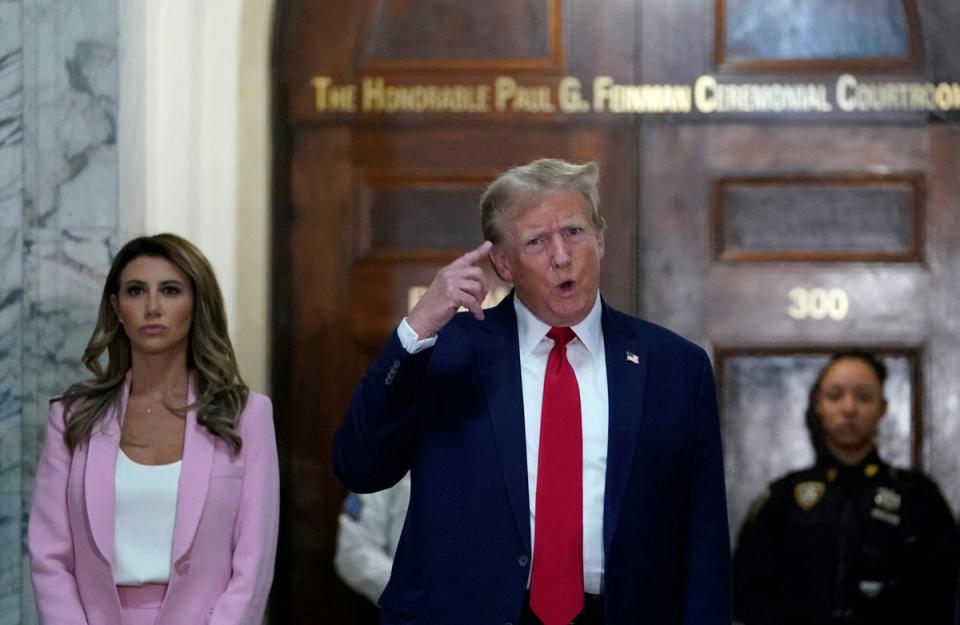 Donald Trump speaks to reporters alongside his attorney Alina Habba, left, outside Judge Arthur Engoron’s courtroom in New York County Supreme Court on 7 December (AFP via Getty Images)