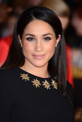 <p>For the U.K. premiere of <em>The Hunger Games: Catching Fire</em> in 2013, Meghan wore slick hair tucked behind her ears. (Photo: Getty Images) </p>