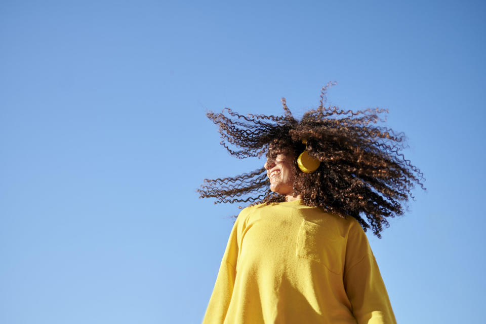 woman smiling with making her hair twirl