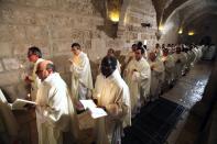 Members of the clergy attend the Christmas midnight mass led by Fouad Twal (not seen), the Latin Patriarch of Jerusalem, at the Church of St. Catherine, which is connected to the Church of Nativity, in the West Bank town of Bethlehem December 25, 2013. REUTERS/ Musa al-Shaer/Pool (WEST BANK - Tags: RELIGION)