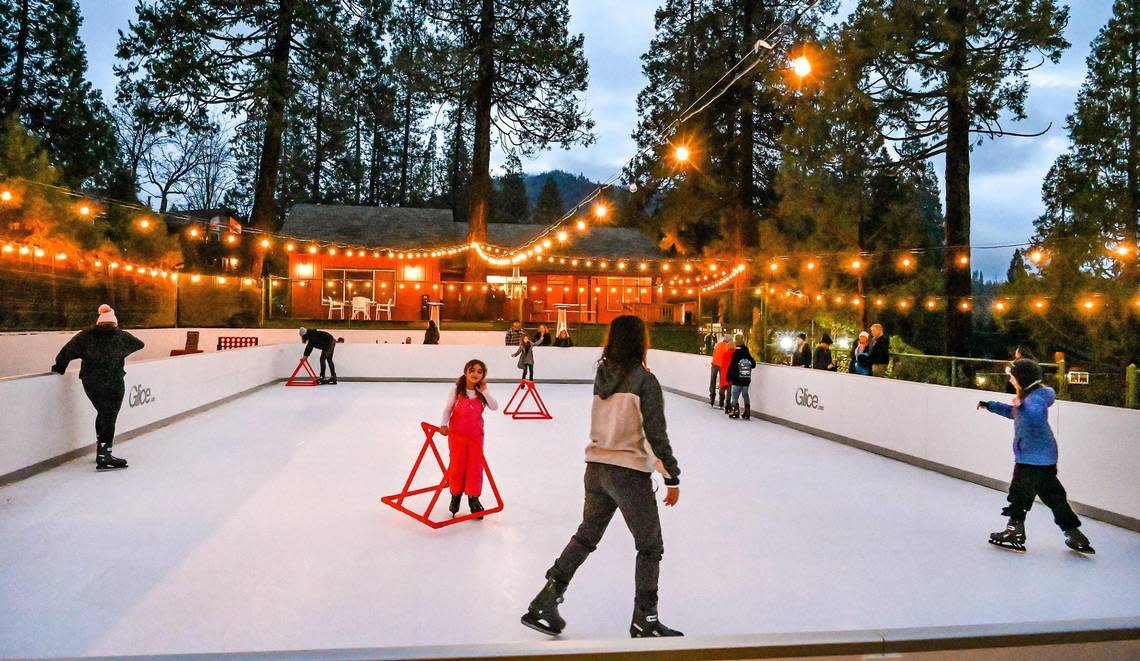 Visitors glide around on the new synthetic skate rink at The Pines Resort on Bass Lake on Wednesday, Dec. 28, 2022. The rink is a new wintertime amenity at the resort and has two sessions a day.