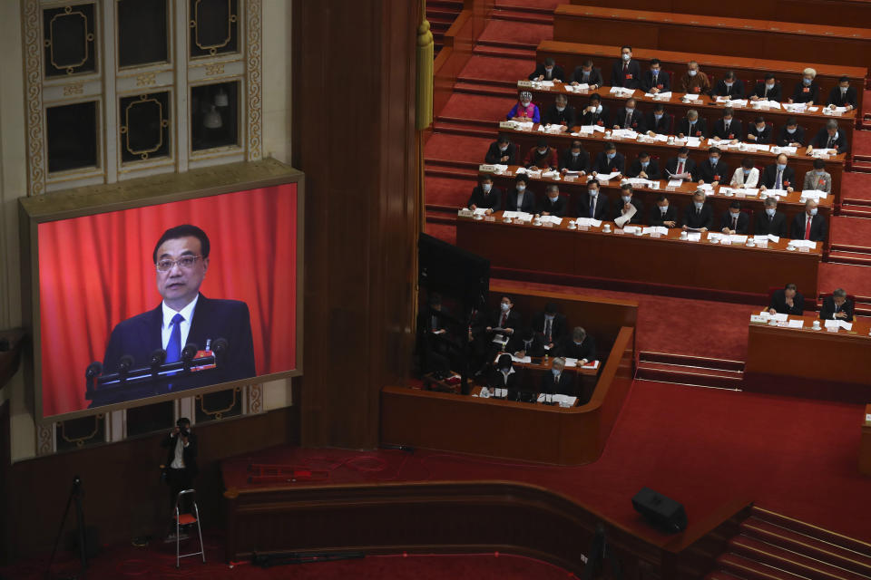 A video screen shows Chinese Premier Li Keqiang as he delivers the government work report during the opening session of China's National People's Congress (NPC) at the Great Hall of the People in Beijing, Friday, May 22, 2020. (AP Photo/Ng Han Guan, Pool)