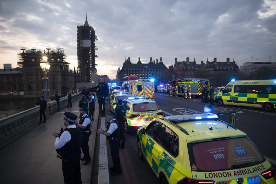 London Ambulance staff, police officers and firefighters take part in the weekly "clap for our carers" as they stand on Westminster Bridge backdropped by a scaffolded Big Ben and the Houses of Parliament in London, during the lockdown to try and stop the spread of coronavirus, Thursday, April 16, 2020. The applause takes place across Britain every Thursday at 8pm local time to show appreciation for healthcare workers, emergency services, armed services, delivery drivers, shop workers, teachers, waste collectors, manufacturers, postal workers, cleaners, vets, engineers and all those helping people with coronavirus and keeping the country functioning while most people stay at home in the lockdown. (AP Photo/Matt Dunham)