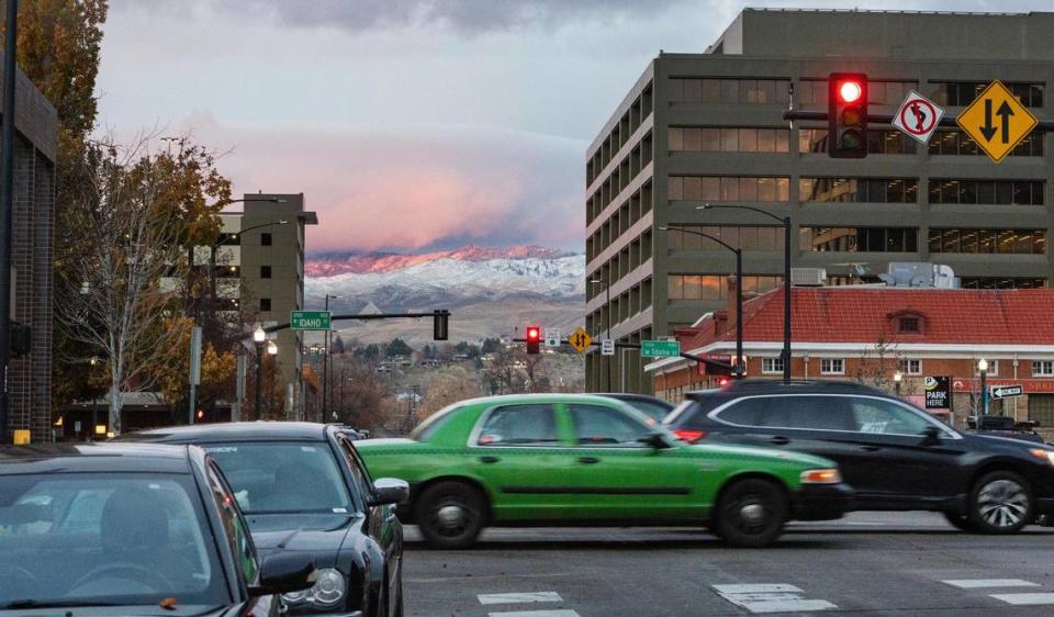 A green car from Boise City Taxi drives last month on Main Street in downtown Boise. The 29-year-old company is discontinuing service after Dec. 23.