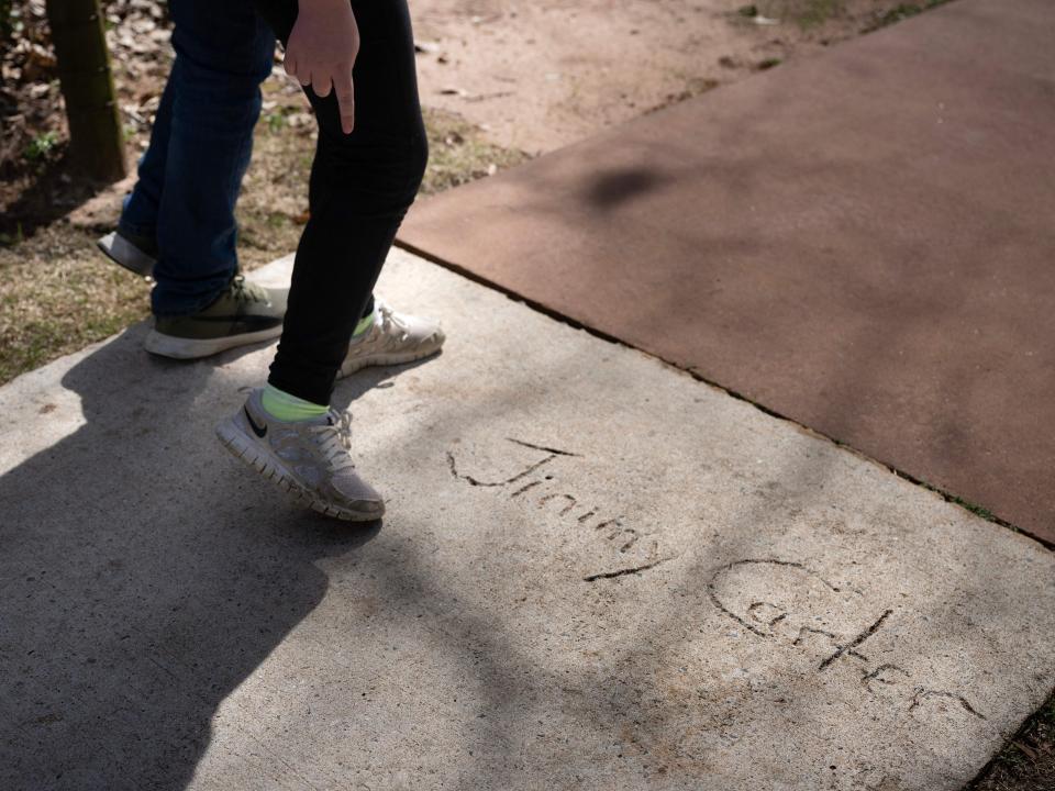 People walk past the signature and hand prints of former US President Jimmy Carter