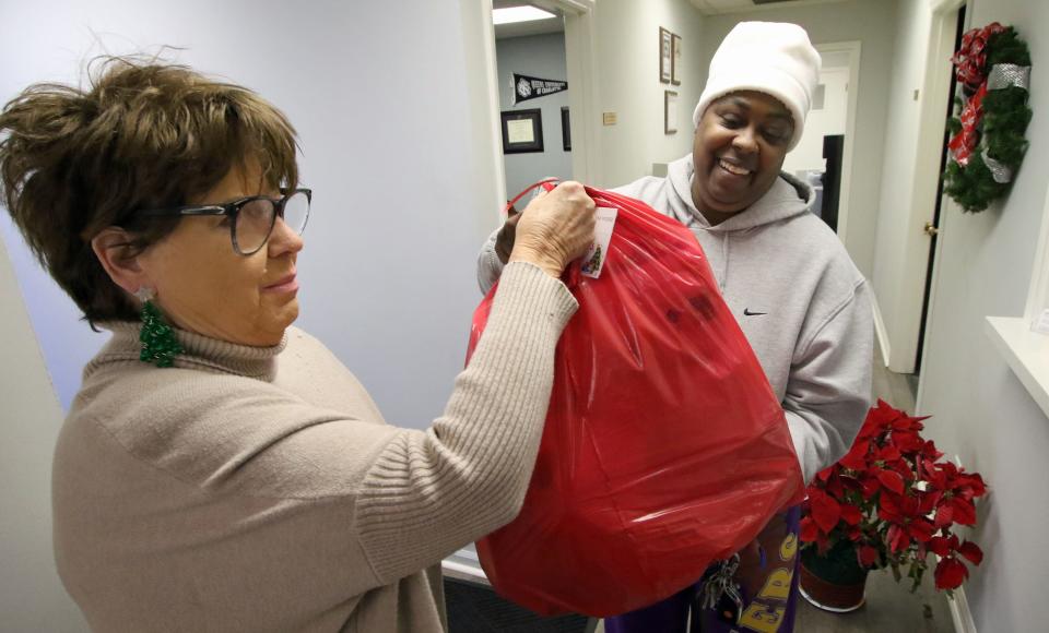 Freida Pollock hands a Wish Sack to Andra Bell for the Senior Christmas Wish program at the United Way offices on East Franklin Boulevard Tuesday morning, Dec. 12, 2023.