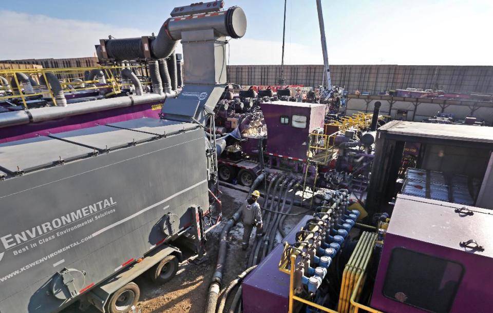 In this March 25, 2014 photo, a worker walks among huge pumps and other equipment at the site of a hydraulic fracturing operation at an Encana Corp. well pad near Mead, Colo. The first experimental use of hydraulic fracturing was in 1947, and more than 1 million U.S. oil and gas wells have been fracked since, according to the American Petroleum Institute. The National Petroleum Council estimates that up to 80 percent of natural gas wells drilled in the next decade will require hydraulic fracturing. (AP Photo/Brennan Linsley)