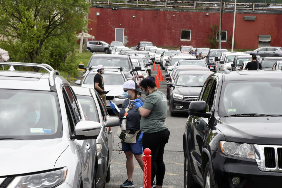 FILE - In this May 25, 2020, file photo, agents Amanda Toma and Ashley Brodeur work with customers outside in the parking lot of cannabis purveyor Berkshire Roots in Pittsfield, Mass. Laws legalizing recreational marijuana may lead to more traffic deaths, two new studies suggest, although questions remain about how they might influence driving habits. Previous research has had mixed results and the new studies, published Monday, June 22, 2020, in JAMA Internal Medicine, can’t prove that the traffic death increases they found were caused by marijuana use. (Gillian Jones/The Berkshire Eagle via AP, File)