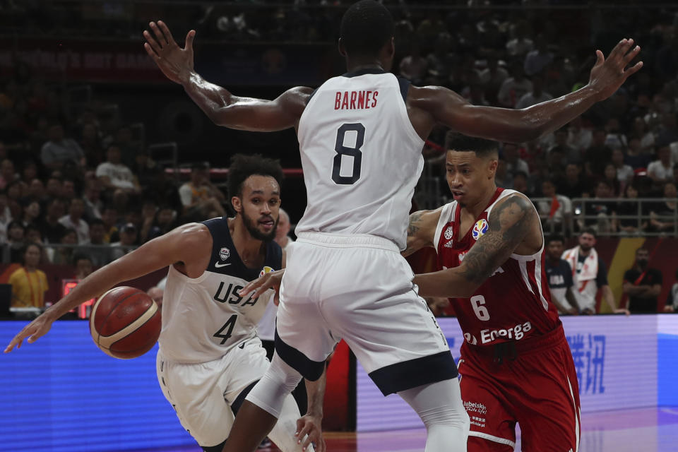 Poland's A.J. Slaughter attempts to get past United States' Harrison Barnes and United States' Derrick White at left during a consolation playoff game for the FIBA Basketball World Cup at the Cadillac Arena in Beijing on Saturday, Sept. 14, 2019. U.S. defeated Poland 87-74 (AP Photo/Ng Han Guan)