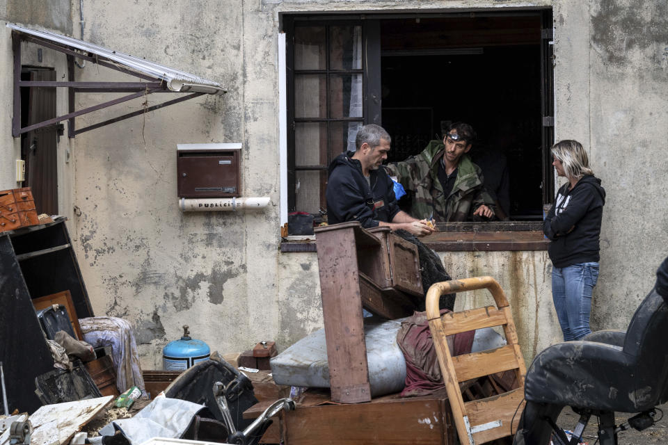 Residents talk with a soldier, center, after flash floods in the town of Villegailhenc, southern France, Monday, Oct.15, 2018. Flash floods tore through towns in southwest France, turning streams into raging torrents that authorities said killed several people and seriously injured at least five others. (AP Photo/Fred Lancelot)
