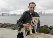 FILE - This May 16, 2011 photo shows Timothy Ray Brown with his dog, Jack, on Treasure Island in San Francisco. Brown, who was known for years as the Berlin patient, had a transplant in Germany from a donor with natural resistance to the AIDS virus. It was thought to have cured Brown's leukemia and HIV. But in an interview Thursday, Sept. 24, 2020, Brown said his cancer returned last year and has spread widely. His case has inspired scientists to seek more practical ways to try to cure the disease. (AP Photo/Eric Risberg)