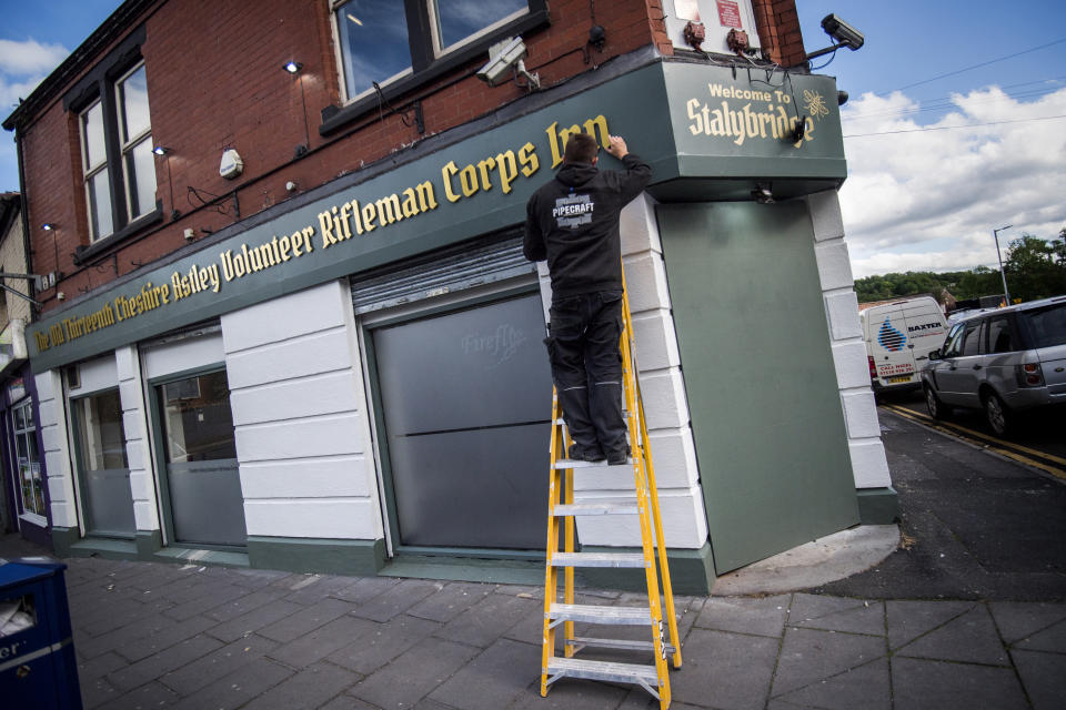 STALYBRIDGE, ENGLAND - MAY 31: A workman finishes the lettering on the sign of The Old Thirteenth Cheshire Astley Volunteer Rifleman Corps Inn, the pub with the longest name in the world on May 31, 2019 in Stalybridge, England. The pub which reopens tomorrow was awarded a Guinness World Record in 1995 and has now reopened close to the Q Inn, the pub with the shortest name in the world. (Photo by Anthony Devlin/Getty Images)