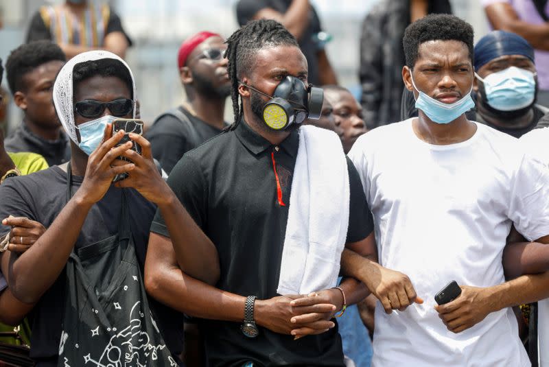 Demonstrators wearing protective masks take part in a protest over alleged police brutality, in Lagos