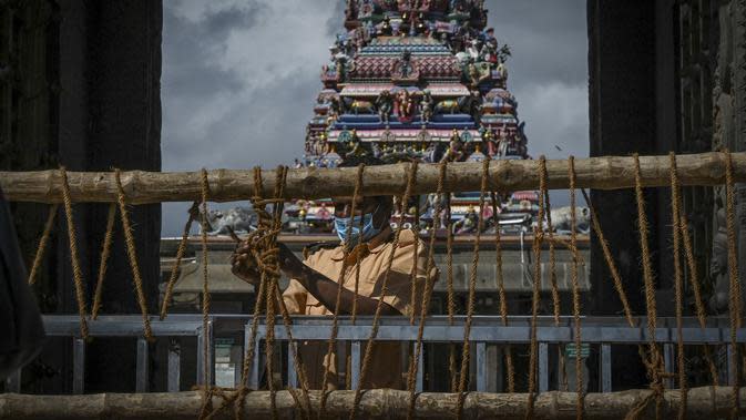 Sebuah barikade ditempatkan di depan kuil Kapaleeshwar, setelah tempat ibadah keagamaan ditutup untuk umum untuk mengekang lonjakan virus corona Covid-19 sesuai arahan pemerintah negara bagian di Chennai (7/1/2022). (AFP/Arun Sankar)