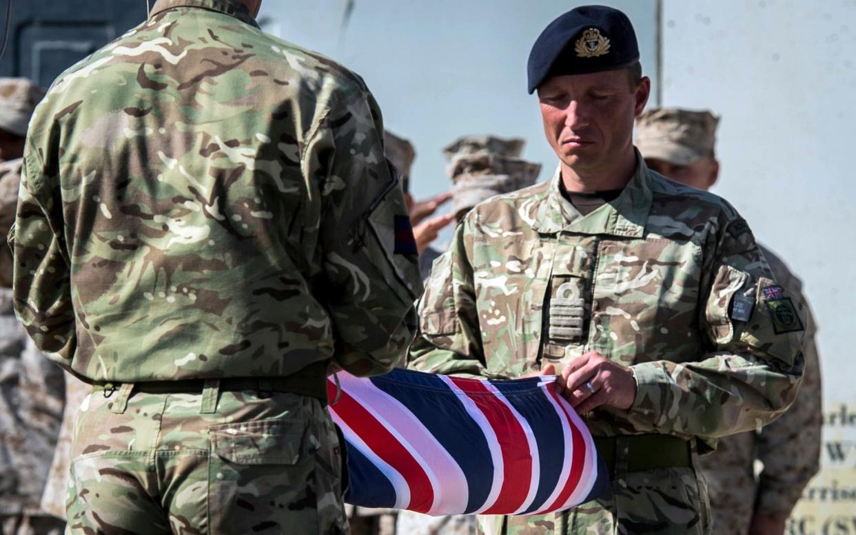 Captain Matthew Clark, right, and Warrant Officer 1 John Lilley fold the last Union flag to fly above the skies of Helmand Province, Afghanistan. The flag will be returned back to the UK after a ceremony at Camp Bastion - Ben Birchall /PA Archive